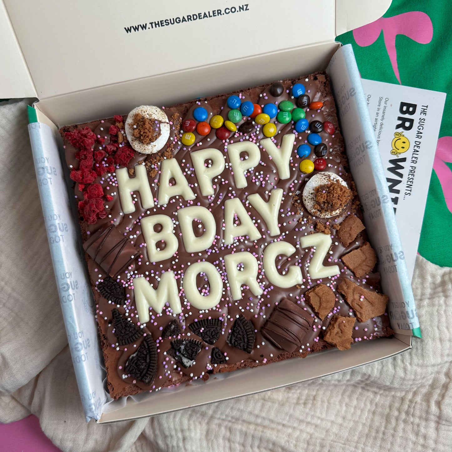 Loaded custom message brownie - 3 rows of chocolate letters surrounded by a chaotic amount of your favourite flavours, including oreo, raspberry, M&M, biscoff, s'mores and kinder bueno