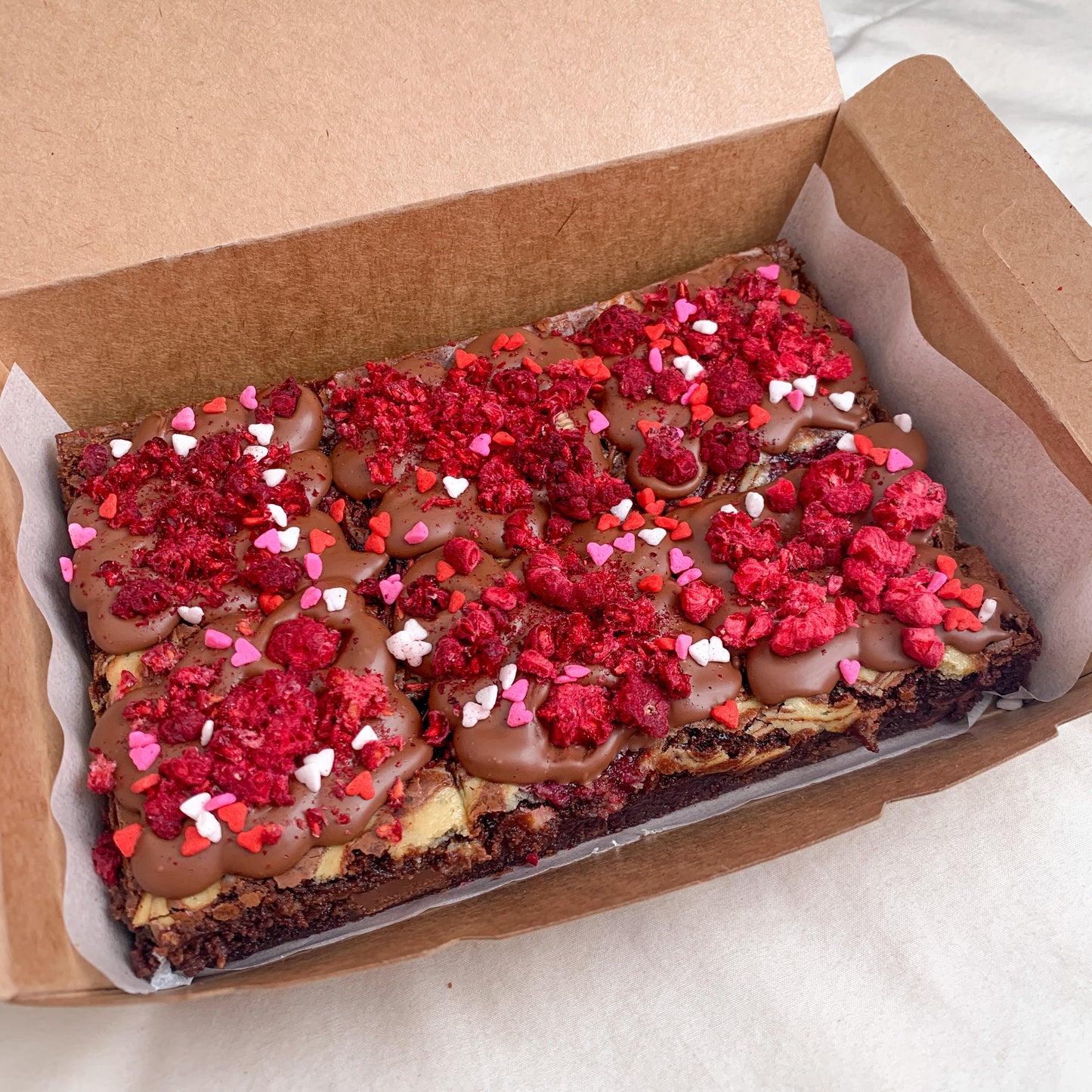 Our delicious chocolate brownie with swirls of cheesecake sauce and raspberry compote baked into it and topped with some freezedried raspberries!